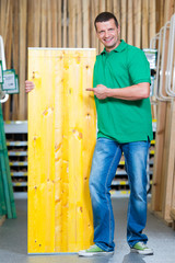 schreiner zeigt auf holzplatte