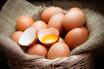Fotobehang broken chicken eggs and egg yolk © comzeal