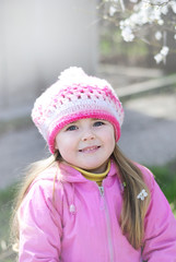 beautiful little girl near a flowering tree