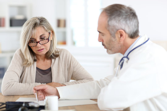 Doctor Giving Medicine To Senior Woman For Arthritis Pain