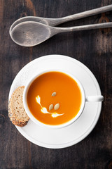 Pumpkin soup with pumpkin seeds in a white mug
