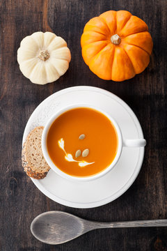 Pumpkin soup with pumpkin seeds in a white cup