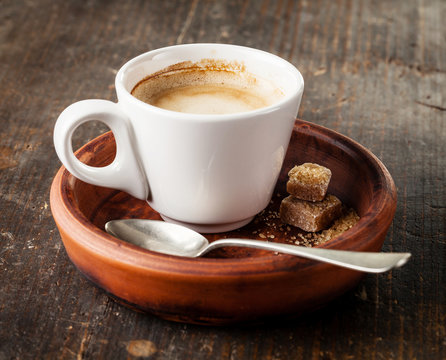 Cup of espresso coffee with brown sugar on dark background