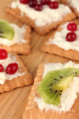 Cookie with cheese and cranberry, kiwi, on wooden background