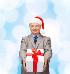 smiling man in suit and santa helper hat with gift