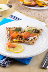 Salmon sandwiches on plate  on wooden table close-up