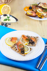 Salmon sandwiches on plate  on wooden table close-up