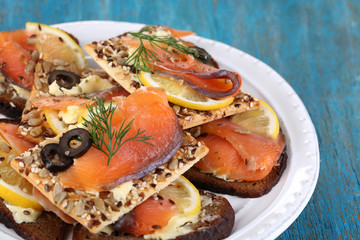 Salmon sandwiches on plate  on wooden table close-up