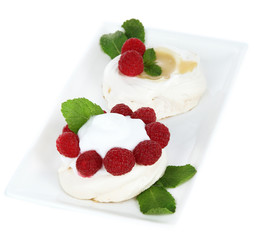Tasty meringue cakes with berries, isolated on white