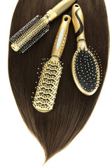 Shiny brown hair with combs isolated on white