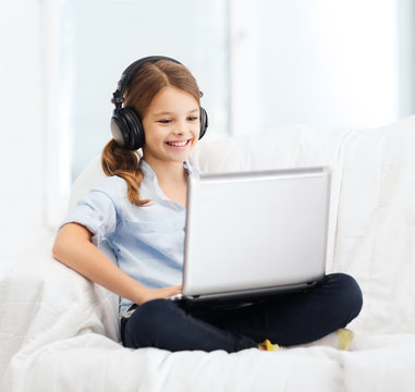 Girl With Laptop Computer And Headphones At Home
