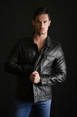 Obraz premium Portrait of attractive young man with leather jacket and jeans