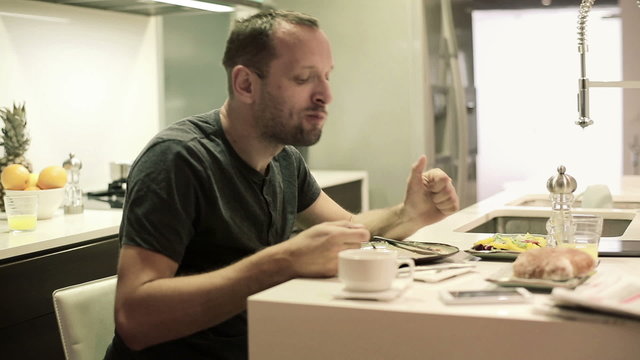 Young man eating meal in the kitchen