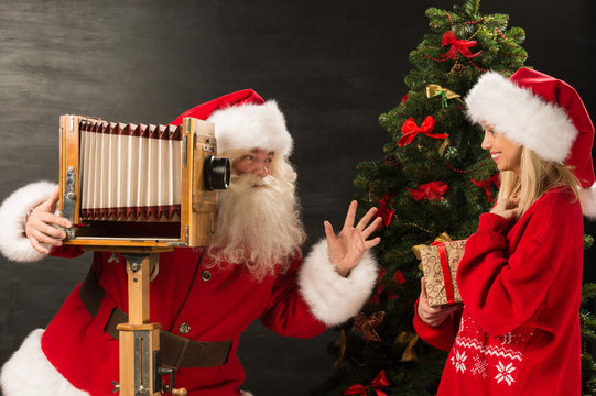 Photo of Santa Claus with his wife taking pictures with Christma