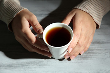 Hands holding mug of hot drink, close-up