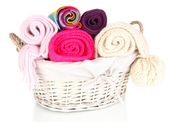 Fototapeta na wymiar Warm knitted scarves in basket isolated on white