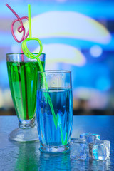 Glasses of cocktails, on bright background
