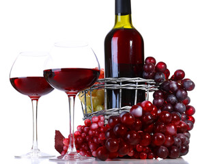 Wineglasses with red wine, grape and bottle isolated on white