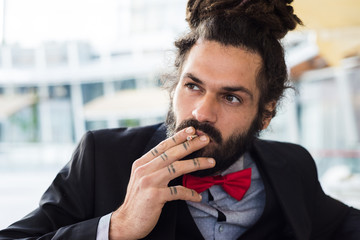 Stylish elegant dreadlocks businessman smoking
