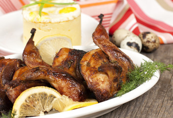 Roasted quail on white plate