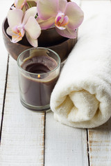 Spa concept. Bath towel, fresh flowers on white wooden backgroun