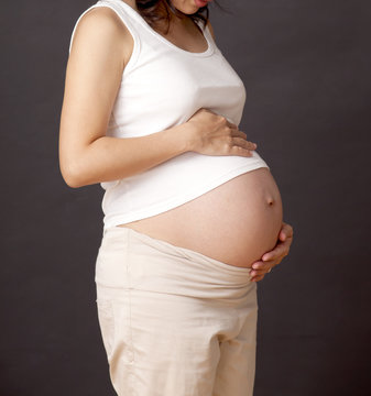 Pregnant woman with hands over tummy.