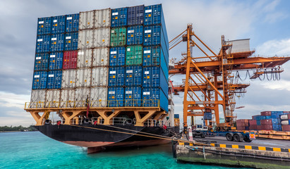 Container Cargo freight ship with working crane loading