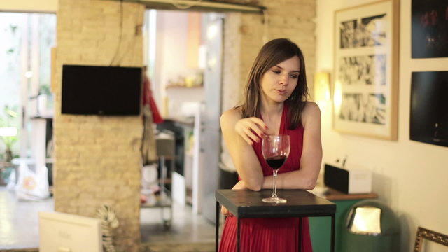 Elegant sad, pensive woman drinking wine and waiting at home