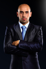 Portrait of a serious businessman on black background