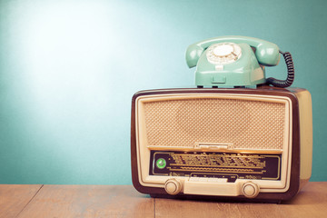 Retro old radio and mint green telephone on wooden table