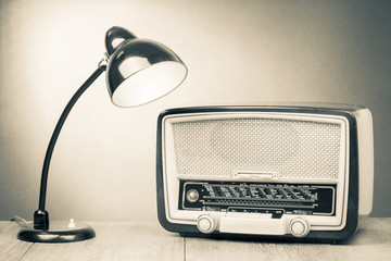 Retro old desk lamp and radio on table sepia photography