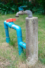 Fototapeta na wymiar water tap in garden with grass background