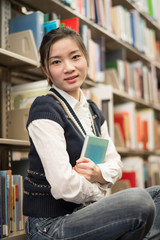 Girl huggering a book near bookshelf
