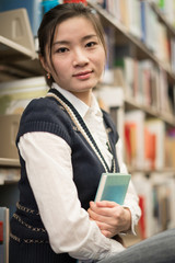 Girl huggering a book near bookshelf