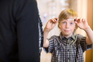 Obraz premium Boy Holding Spectacles With Mother In Foreground At Shop