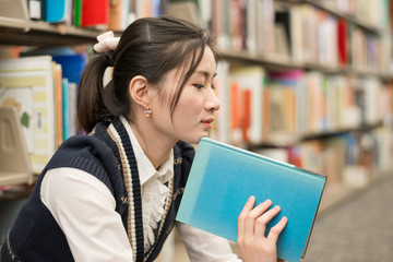 Woman holding a book near bookshelf