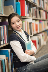 Girl huggering a book near bookshelf