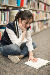 Woman reading a book near bookshelf