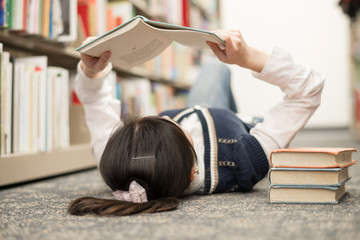 Student laying on floor reading book