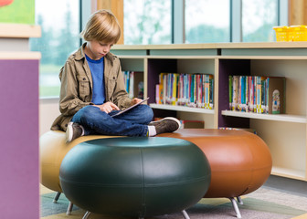 Schoolboy Using Digital Tablet In Library