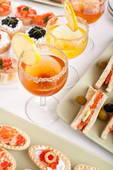 banquet table with drinks, sandwiches and canapes