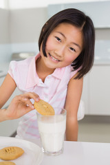 Portrait of a smiling girl enjoying cookies and milk