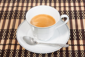 a cup of coffee on bamboo mat