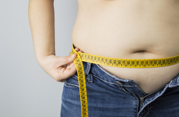 obese woman measuring her waist