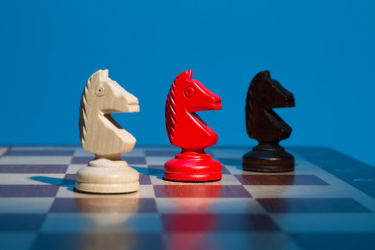 Three chess knight on chessboard on blue background