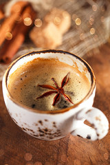 A cup of spiced coffee with anis star and cinamon sticks and sug