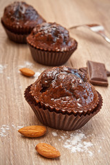 Chocolate cupcakes with ingredients on the wood background