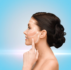 smiling young woman pointing to her cheek