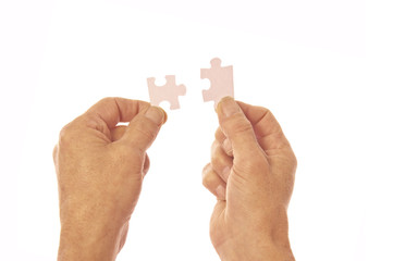 Two hands connecting puzzle pieces