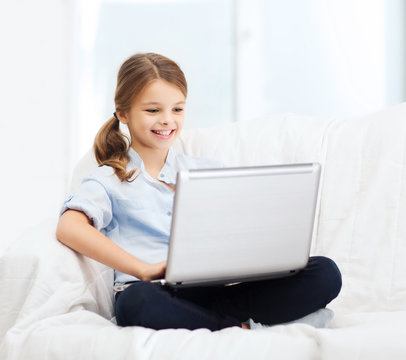 smiling girl with laptop computer at home